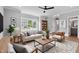 Bright living room featuring a ceiling fan, large window, hardwood floors, and neutral decor at 2521 Newbold St, Raleigh, NC 27603