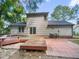 Expansive backyard with a wooden deck and brick patio perfect for outdoor entertainment and relaxation at 2705 Ramblegate Ln, Durham, NC 27705