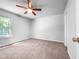 Cozy bedroom featuring carpet flooring, a ceiling fan, and a bright window at 2705 Ramblegate Ln, Durham, NC 27705