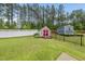 Spacious backyard with sheds surrounded by a white privacy fence and manicured lawn at 2909 Landon Pines Ct, New Hill, NC 27562