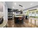 Modern kitchen with stainless steel appliances, black cabinetry, granite countertops, and a central island at 2909 Landon Pines Ct, New Hill, NC 27562