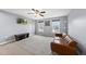 Cozy living room boasts a leather sofa, TV, and natural light from two windows at 2909 Landon Pines Ct, New Hill, NC 27562