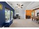 Bright living room with large windows, a ceiling fan, and neutral carpeting leading into the dining area at 2909 Landon Pines Ct, New Hill, NC 27562