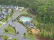 Aerial view of a community pool and park surrounded by lush greenery and neighborhood streets at 2909 Landon Pines Ct, New Hill, NC 27562