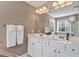 Bathroom featuring a double sink vanity with a large mirror and ample lighting for a bright space at 300 Quarryrock Road Rd, Holly Springs, NC 27540