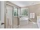 Bathroom featuring a tiled shower, large soaking tub, and window for natural light at 300 Quarryrock Road Rd, Holly Springs, NC 27540