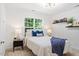 Bedroom featuring a cozy bed, side table, and a window providing natural light to the space at 300 Quarryrock Road Rd, Holly Springs, NC 27540