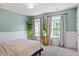 Bright bedroom featuring natural light from two windows and soothing, light blue walls at 300 Quarryrock Road Rd, Holly Springs, NC 27540