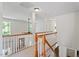 Upstairs hallway with white railings and carpeted floors for safety at 300 Quarryrock Road Rd, Holly Springs, NC 27540