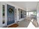 Inviting front porch with a rocking chair, ceiling fan, wreath, and ample natural light at 300 Quarryrock Road Rd, Holly Springs, NC 27540