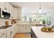 Well-lit kitchen with stainless steel appliances, white cabinets, and hardwood floors throughout the home at 300 Quarryrock Road Rd, Holly Springs, NC 27540