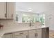 Bright kitchen with stainless steel appliances, white cabinets, granite countertops, and lots of natural light at 300 Quarryrock Road Rd, Holly Springs, NC 27540