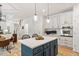 Open concept kitchen with island, stainless steel appliances, and view into the living room and dining area at 300 Quarryrock Road Rd, Holly Springs, NC 27540