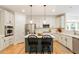 Modern kitchen with stainless steel appliances, white cabinets, a blue island, and hardwood floors at 300 Quarryrock Road Rd, Holly Springs, NC 27540