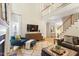 Bright, high ceiling living room with fireplace, hardwood floors and an open staircase leading to the second floor at 300 Quarryrock Road Rd, Holly Springs, NC 27540