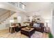 Spacious living room featuring a large sectional sofa, hardwood floors and staircase to the second floor at 300 Quarryrock Road Rd, Holly Springs, NC 27540
