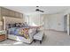 Main bedroom featuring a tufted headboard bed, sitting bench, and neutral décor with natural light at 300 Quarryrock Road Rd, Holly Springs, NC 27540