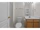 This well-lit bathroom offers a vanity with storage and a toilet with a white door at 3027 Maple Ave # U1, Burlington, NC 27215