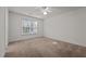 This bright bedroom boasts neutral carpet, a ceiling fan, and a large window for ample light at 3027 Maple Ave # U1, Burlington, NC 27215