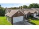 Side view of a brick home featuring a two car garage, dark shutters, and manicured landscaping at 3027 Maple Ave # U1, Burlington, NC 27215