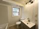 Updated bathroom showcasing vanity sink, tub, tile surround, and modern lighting at 3205 Broyhill Cir, Raleigh, NC 27604