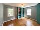 Bedroom featuring hardwood floors, built-in shelves, and gray walls, with natural light from the windows at 3205 Broyhill Cir, Raleigh, NC 27604