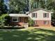 Charming two-story home with red brick and light yellow siding, complemented by lush greenery and a well-manicured lawn at 3205 Broyhill Cir, Raleigh, NC 27604