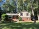 Charming two-story home with red brick and light yellow siding, complemented by lush greenery and a well-manicured lawn at 3205 Broyhill Cir, Raleigh, NC 27604