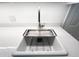 Close-up of a sleek kitchen sink featuring modern fixtures and pristine white countertops at 3205 Broyhill Cir, Raleigh, NC 27604