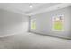 Spacious bedroom with plush carpet, a ceiling fan, and natural light from the two windows at 33 Black Walnut Dr # 185, Garner, NC 27529