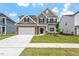 Charming two-story home featuring a stone facade, two-car garage, and a well-manicured lawn at 33 Black Walnut Dr # 185, Garner, NC 27529
