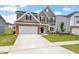 Charming two-story home featuring a stone facade, two-car garage, and a well-manicured lawn at 33 Black Walnut Dr # 185, Garner, NC 27529