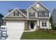 Beautiful two-story home with a stone-accented garage, manicured lawn, and classic architectural details at 33 Black Walnut Dr # 185, Garner, NC 27529