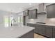 Modern kitchen with gray cabinets, stainless steel appliances, and an island sink at 33 Black Walnut Dr # 185, Garner, NC 27529