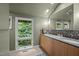 This bathroom has double sinks, wood cabinets, and a large window for natural light at 343 Lakewood Pointe Dr, Roxboro, NC 27574