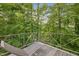 A wooden deck features a wooden lounge chair and has a view of the surrounding forest at 343 Lakewood Pointe Dr, Roxboro, NC 27574
