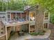 Rear exterior view featuring stone accents, a multi-level deck and patio, and natural surroundings at 343 Lakewood Pointe Dr, Roxboro, NC 27574