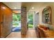 Inviting foyer with stone accent wall, hardwood floors, and a glimpse of the scenic outdoor view at 343 Lakewood Pointe Dr, Roxboro, NC 27574
