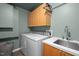 Functional laundry room with modern washer, dryer, sink and ample storage at 343 Lakewood Pointe Dr, Roxboro, NC 27574