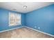 This bedroom has bright blue walls with neutral carpeting, a window with blinds and lighting at 4009 Patriot Ridge Ct, Raleigh, NC 27610