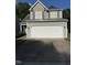 Home featuring a two-car garage, gray siding, and complementary brown accents at 4009 Patriot Ridge Ct, Raleigh, NC 27610