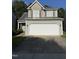 Home featuring a two-car garage, gray siding, and complementary brown accents at 4009 Patriot Ridge Ct, Raleigh, NC 27610