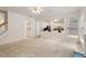 Bright living room open to kitchen, featuring a ceiling fan and multiple windows at 402 Halls Mill Dr, Cary, NC 27519