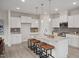 Bright kitchen with white cabinets, stone countertops, stainless steel appliances, and pendant lighting over the island at 433 Old Fashioned Way, Lillington, NC 27546