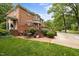 Charming brick home featuring an inviting outdoor space with a brick patio and lush landscaping at 441 Fieldstone Dr, Burlington, NC 27215