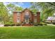 Charming brick two-story home featuring a well-manicured lawn and a welcoming front entrance with a black awning at 441 Fieldstone Dr, Burlington, NC 27215