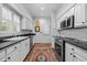 Well-lit kitchen with white cabinets, black countertops, stainless steel appliances, and stylish flooring at 441 Fieldstone Dr, Burlington, NC 27215