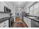 Bright kitchen featuring white cabinetry, stainless steel appliances, and a view to the dining area at 441 Fieldstone Dr, Burlington, NC 27215