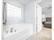Bathroom featuring a soaking tub with chrome fixtures, tile flooring, and a window for natural light at 4502 Joe Cotton Dr, Knightdale, NC 27545