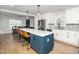 Open kitchen with stylish island seating, white cabinets, stainless steel appliances, and a dining area at 4502 Joe Cotton Dr, Knightdale, NC 27545